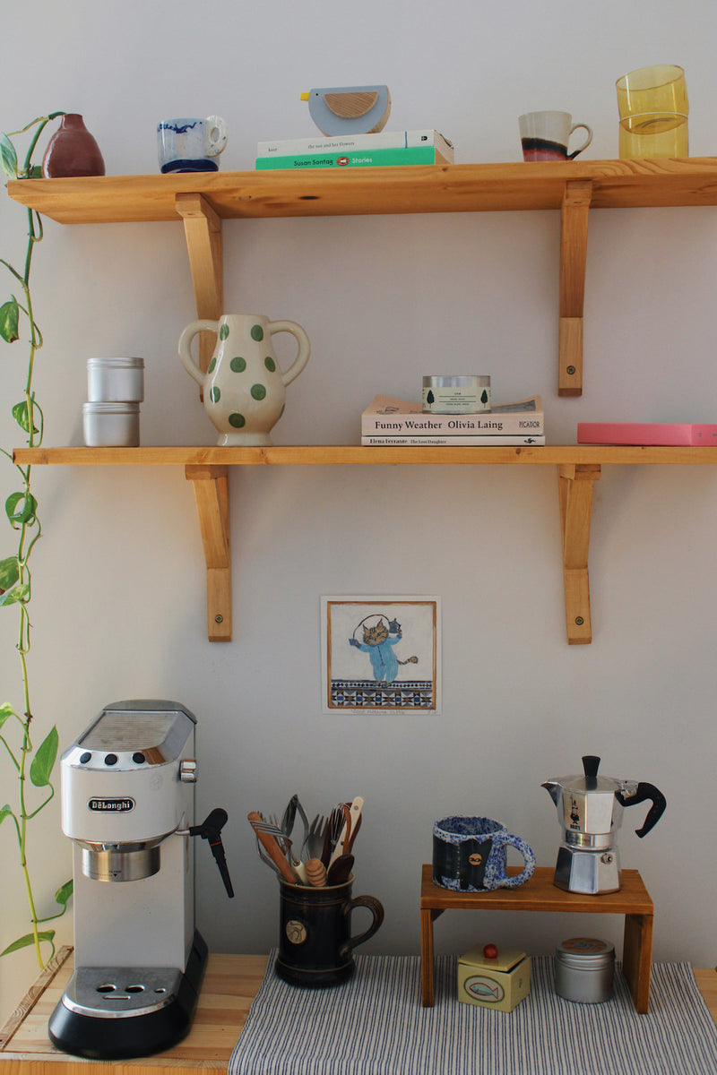 Good Morning Tabby Art Print – illustrated cat art print featuring two cats snuggled together in a blue blanket, styled above a colourful coffee station with ceramic mugs and home accessories
