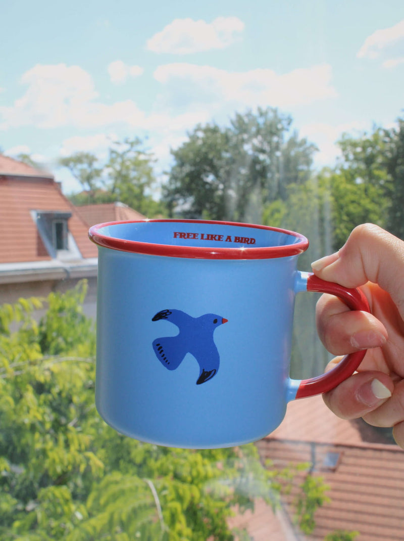 Birdie ceramic mug held outdoors, handmade coffee cup for slow mornings and balcony moments
