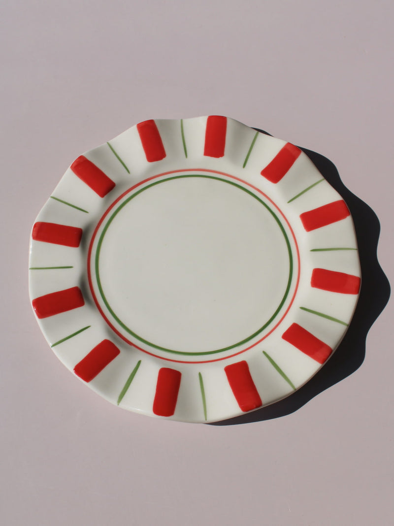 Riviera Ceramic Plate with red and green sunray pattern on scalloped rim, handmade ceramic dessert plate top view