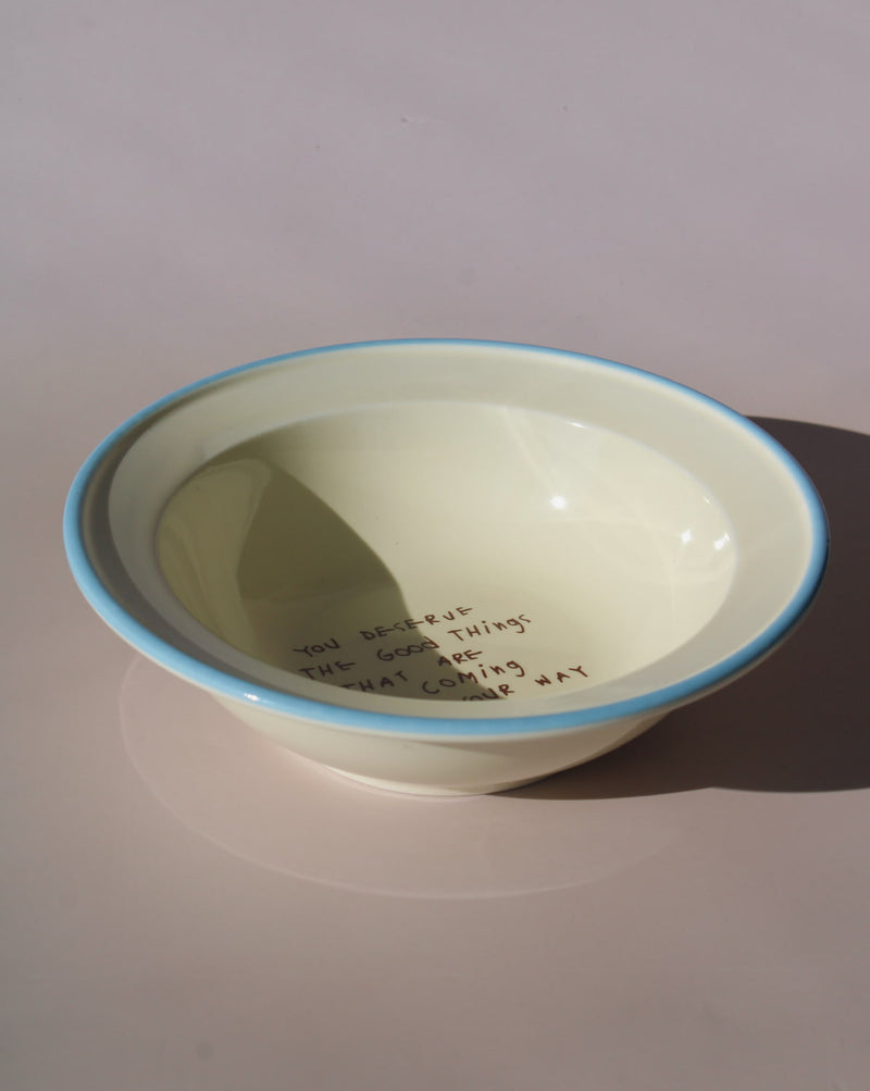 White bowl with blue rim on a light gray background
