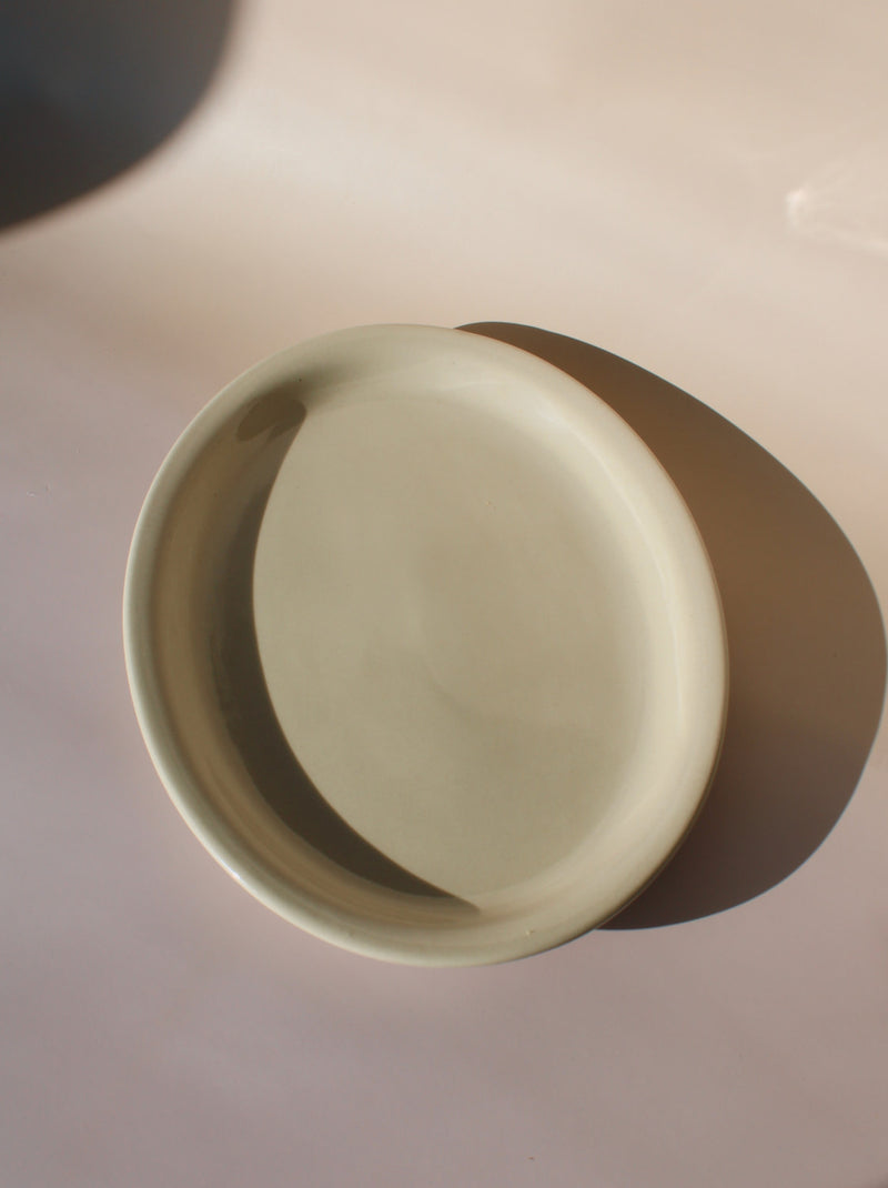Beige ceramic sana plate on a pinkish background