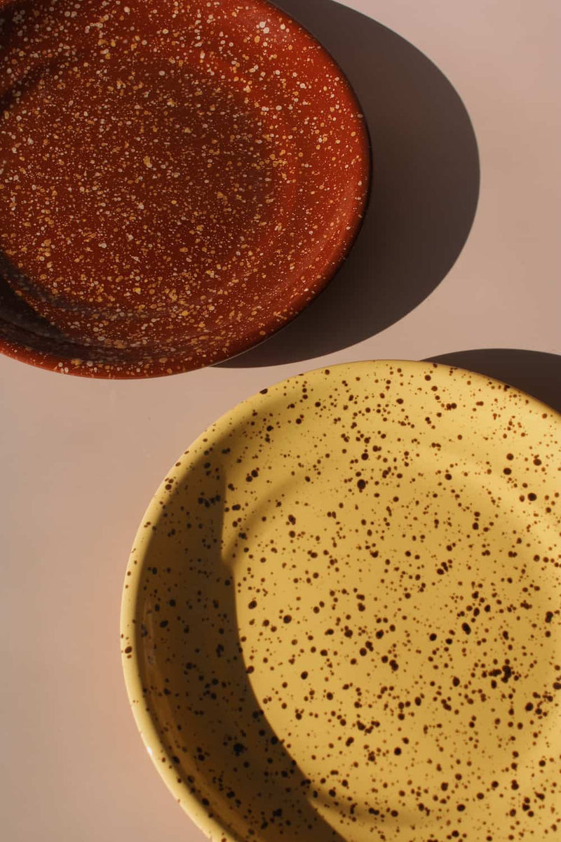 Ocre and Roca ceramic plates styled together, speckled yellow and terracotta handmade stoneware plates.