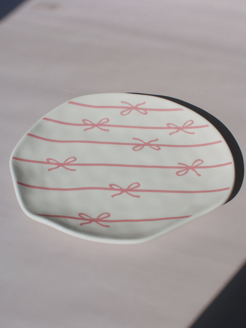 Lina Ceramic Plate with pink bow and ribbon line pattern, organic-shaped handmade ceramic plate top view