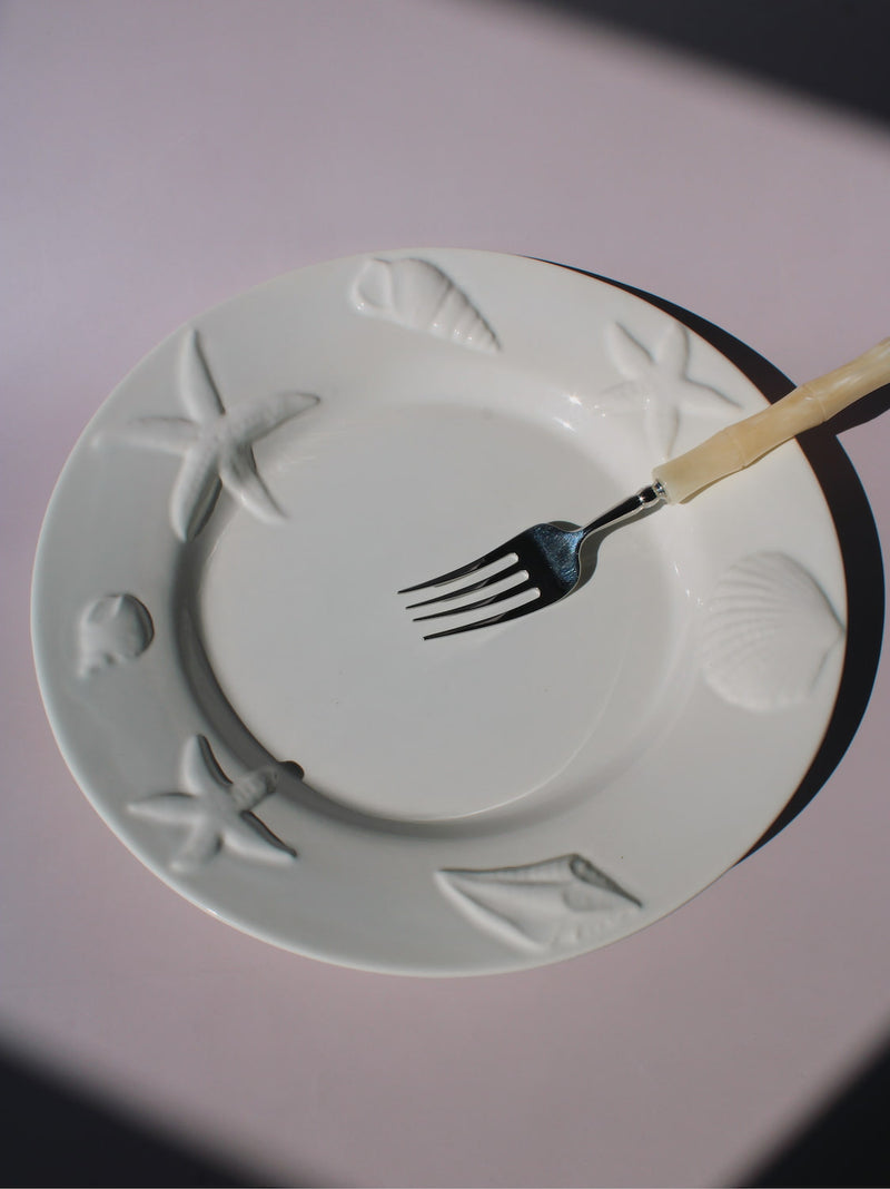 Caspia Ceramic Plate with embossed starfish, seashells and conch border, white ceramic dinner plate top view