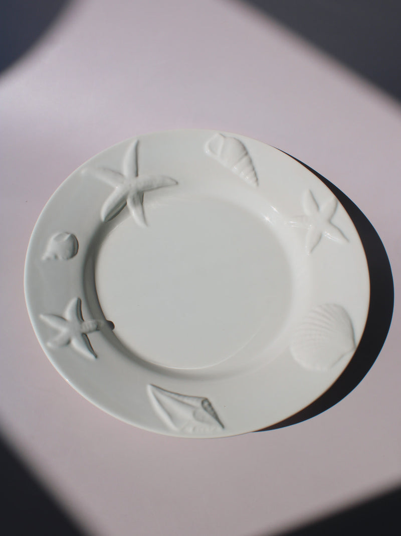 Caspia Ceramic Plate with embossed starfish, seashells and conch border, white ceramic dinner plate top view