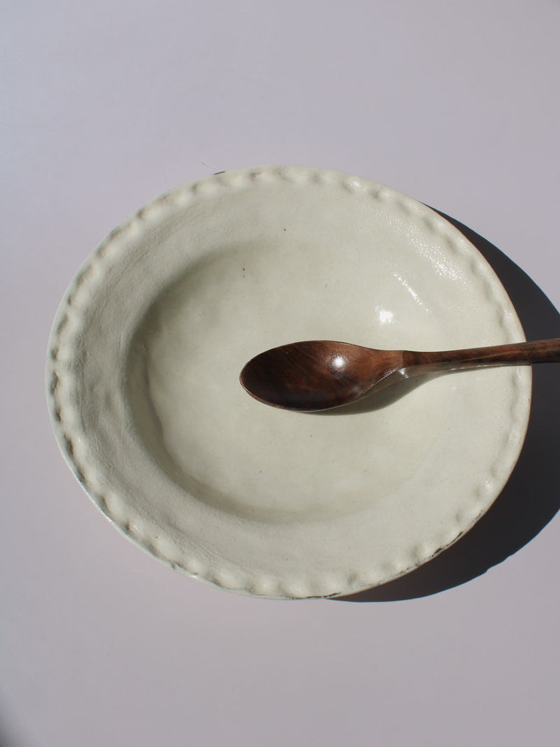 Lunette Ceramic Plate with scalloped beaded edge, styled with a wooden fork, handmade ceramic plate top view