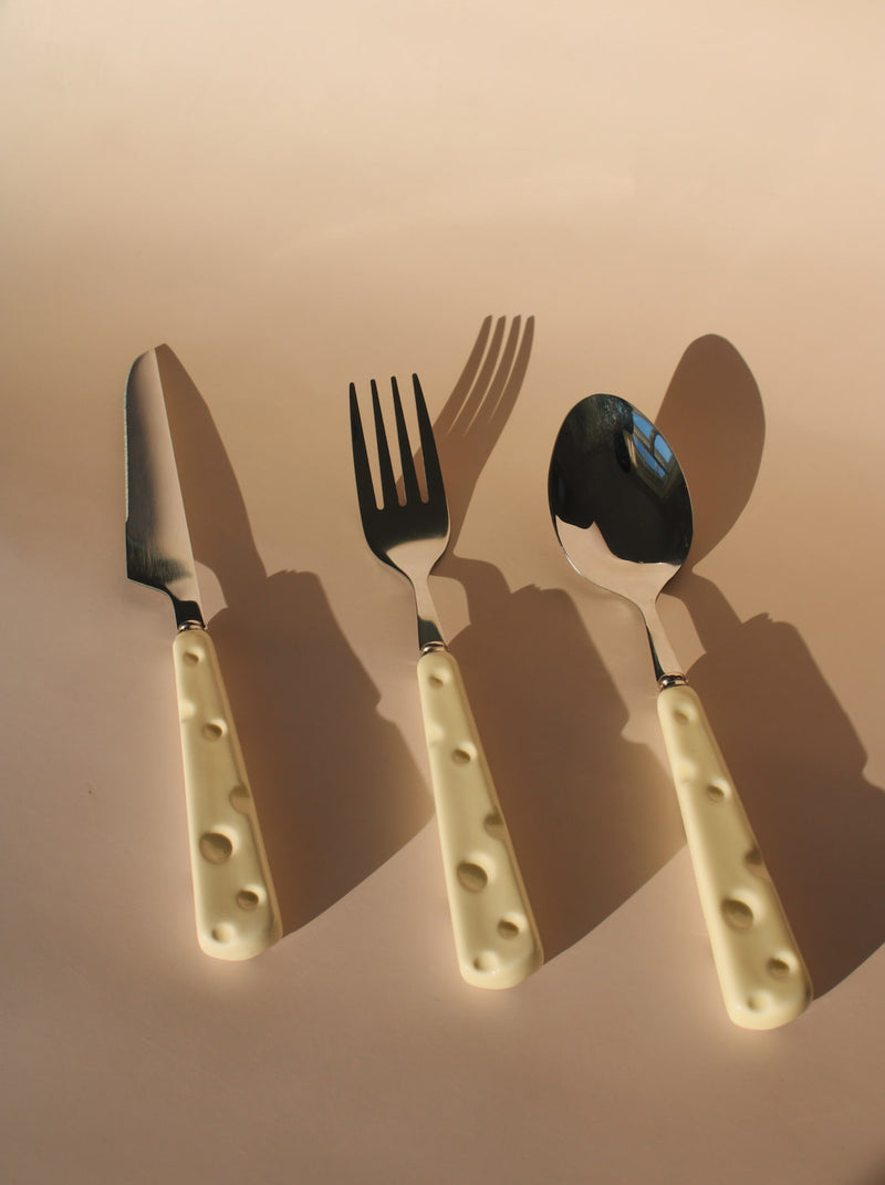Set of cutlery with beige handles on a beige background