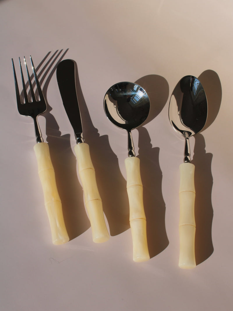 Set of cutlery with beige handles on a light brown background
