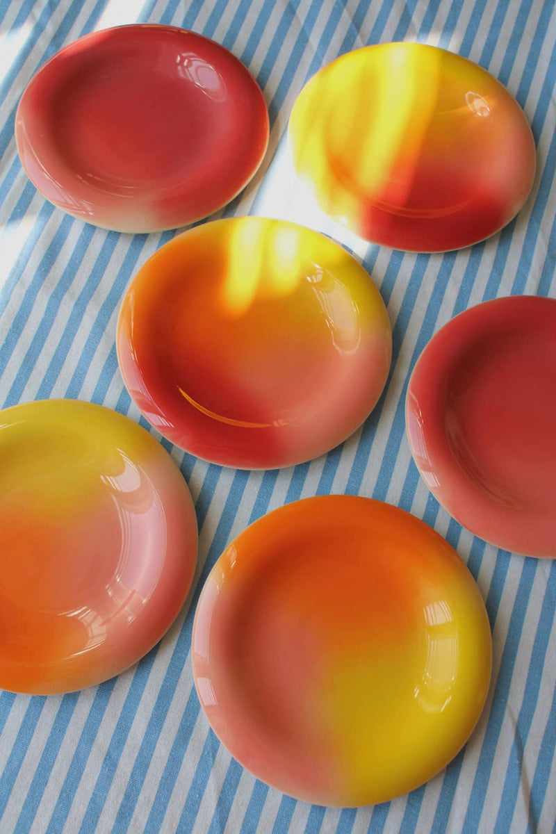 Colourful gradient ceramic plates by Agata Puławska in warm red, coral, orange and yellow tones