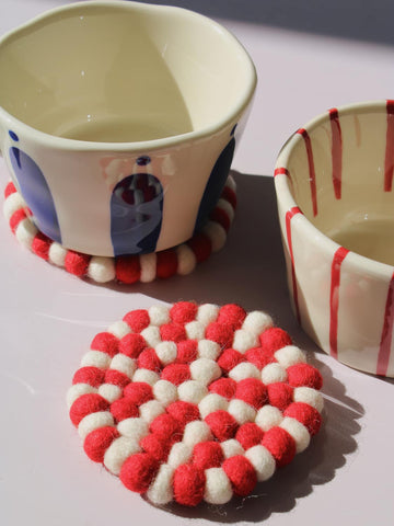Bonbon Handmade Coaster made of red and white felted wool balls, candy-stripe pattern, top view