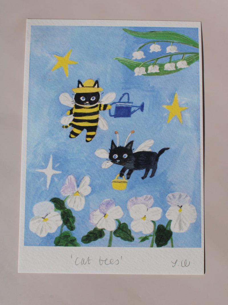 Cat Bees Art Print – illustrated art print featuring two black cats dressed as bees among flowers, styled above a coffee station with colourful ceramics and breakfast tableware