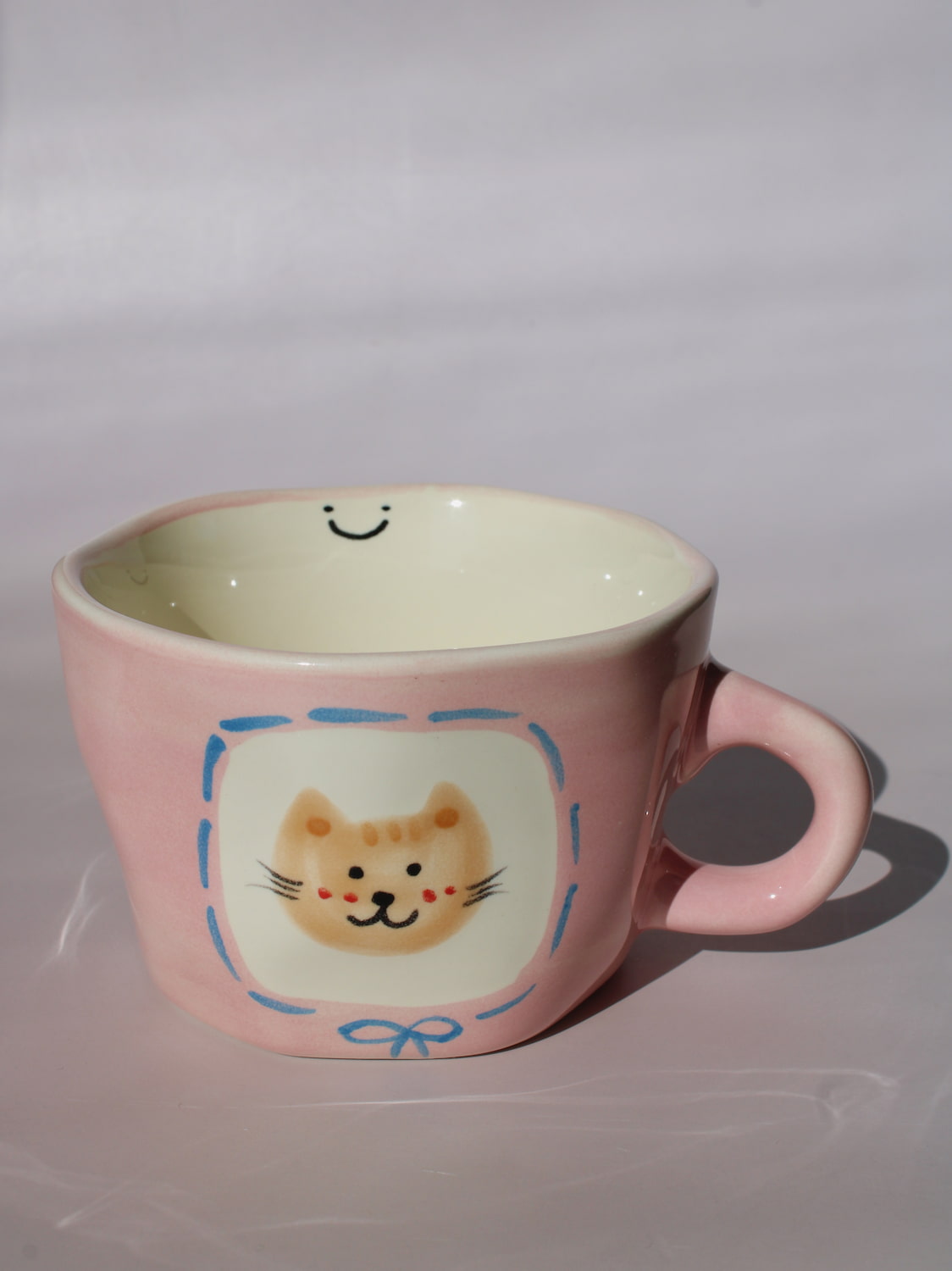 Mimi Ceramic Mug in pink with hand-painted cat face and smiley face inside, handmade ceramic coffee mug