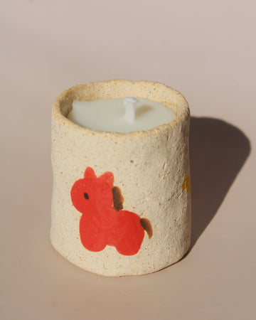 Ponino mini scented candle in handmade ceramic holder with red pony motif, cute decorative candle for cozy shelf or table styling.