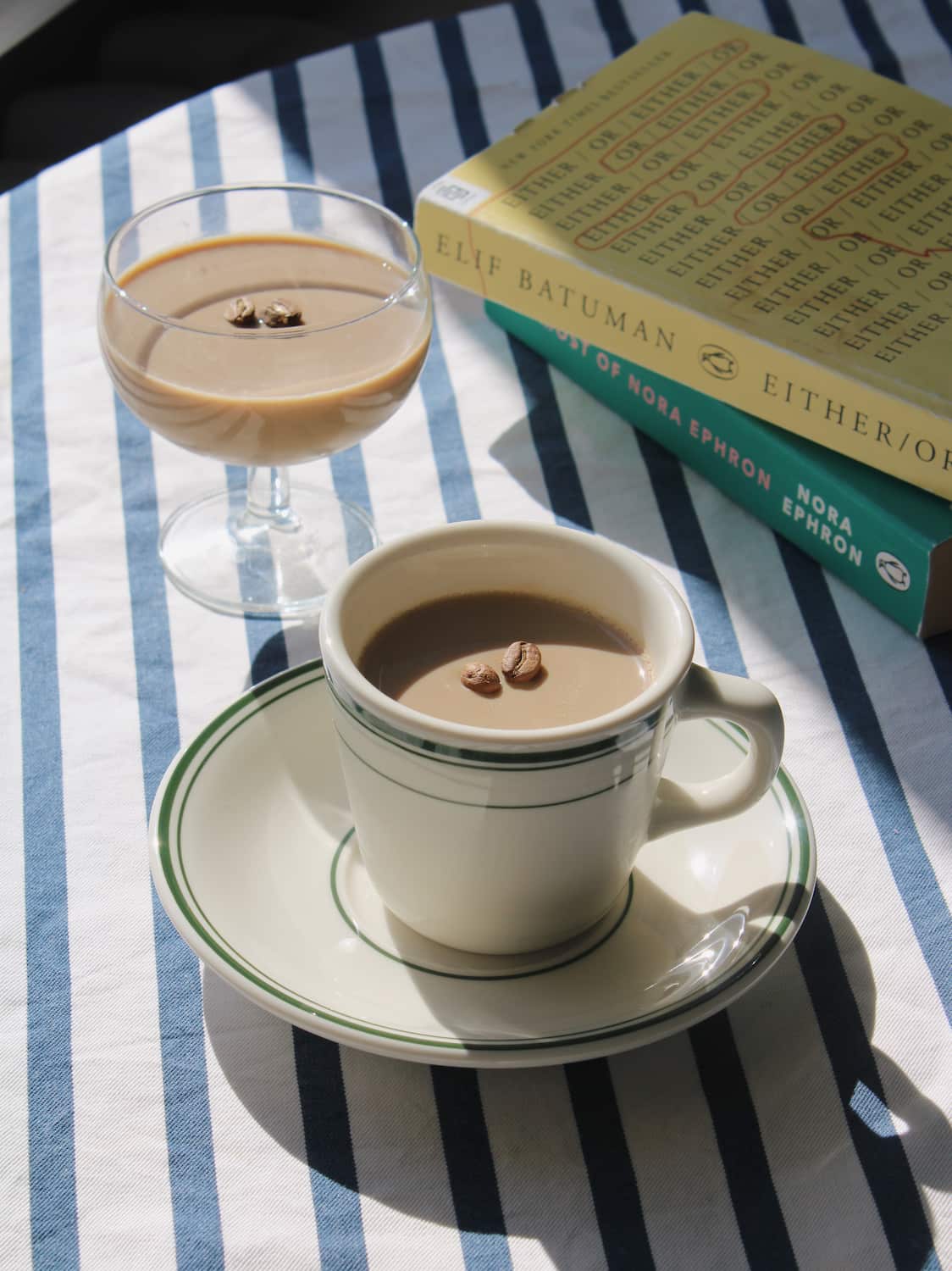 Verde cup and saucer set in cream ceramic with green stripe detail, styled with coffee and a wooden spoon