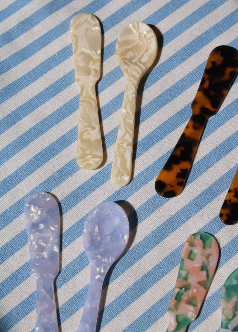 Set of decorative spoons on a blue and white striped background