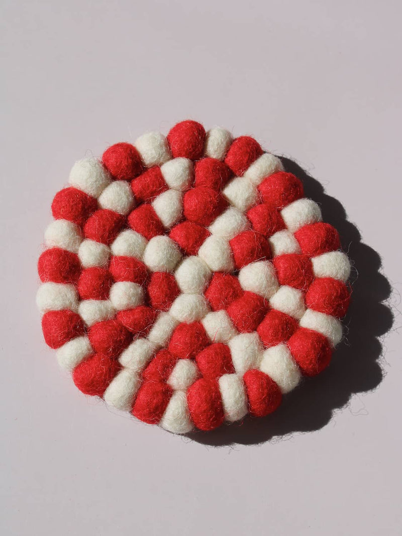 Bonbon Handmade Coaster made of red and white felted wool balls, candy-stripe pattern, top view