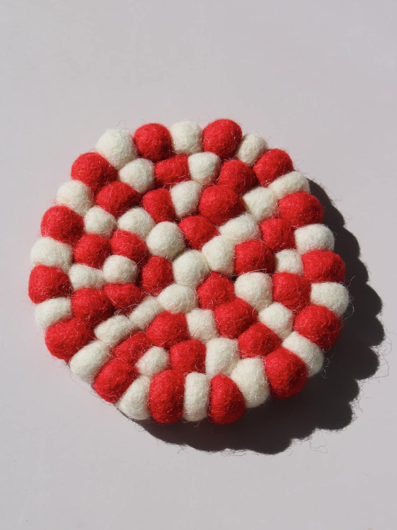 Bonbon Handmade Coaster made of red and white felted wool balls, candy-stripe pattern, top view