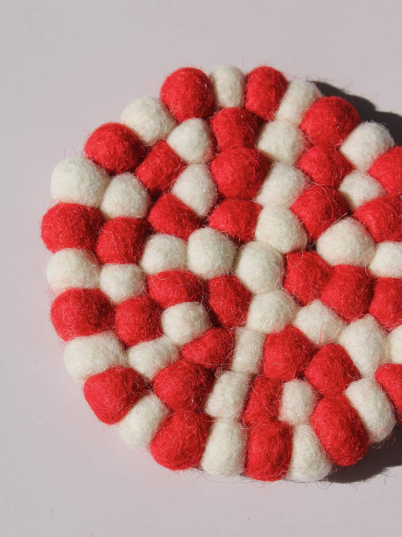 Bonbon Handmade Coaster made of red and white felted wool balls, candy-stripe pattern, top view