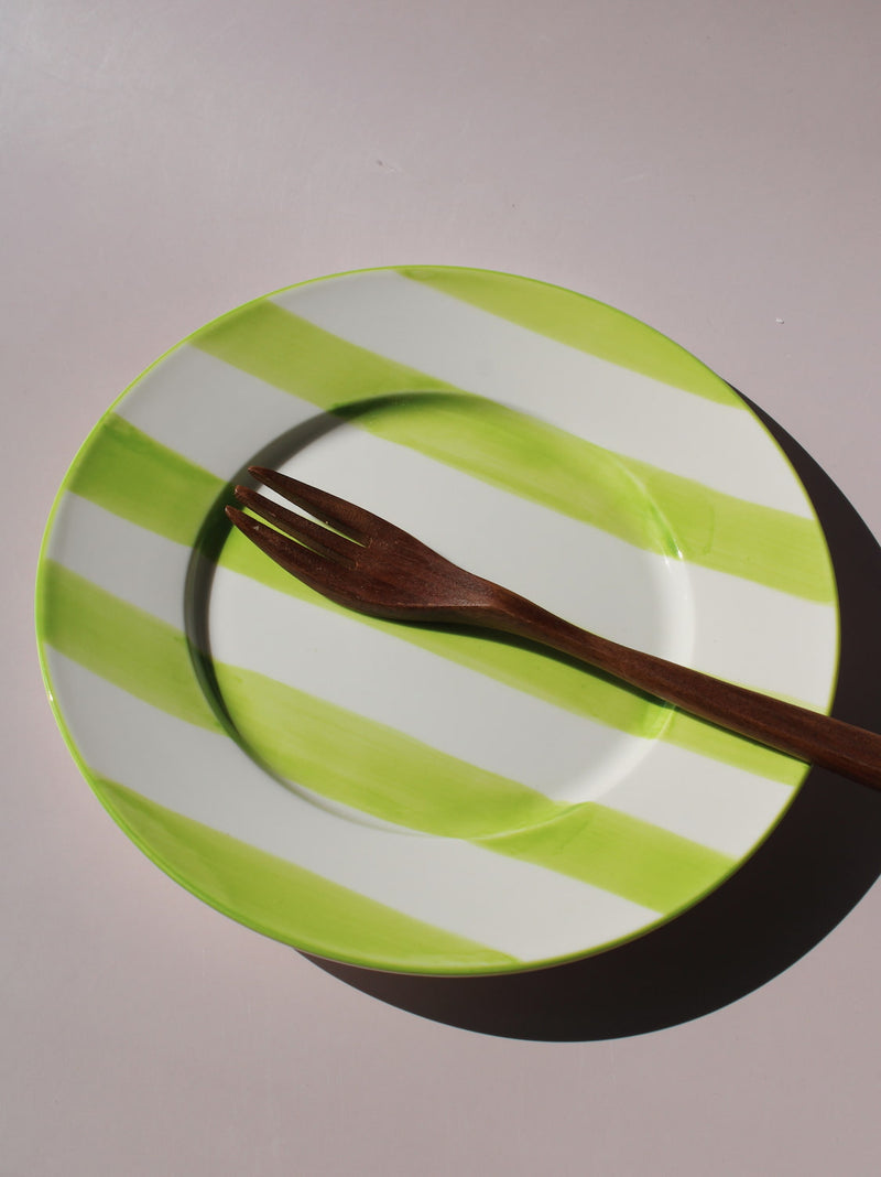 Olia Plate with bold green and white stripes, styled with a wooden fork, handmade ceramic plate top view