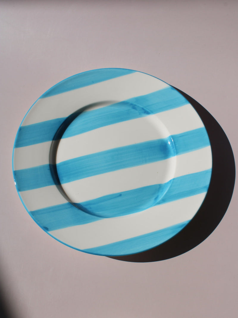 White ceramic plate with hand-painted turquoise blue stripes, Mirel Plate by Mimo Collective, top down view