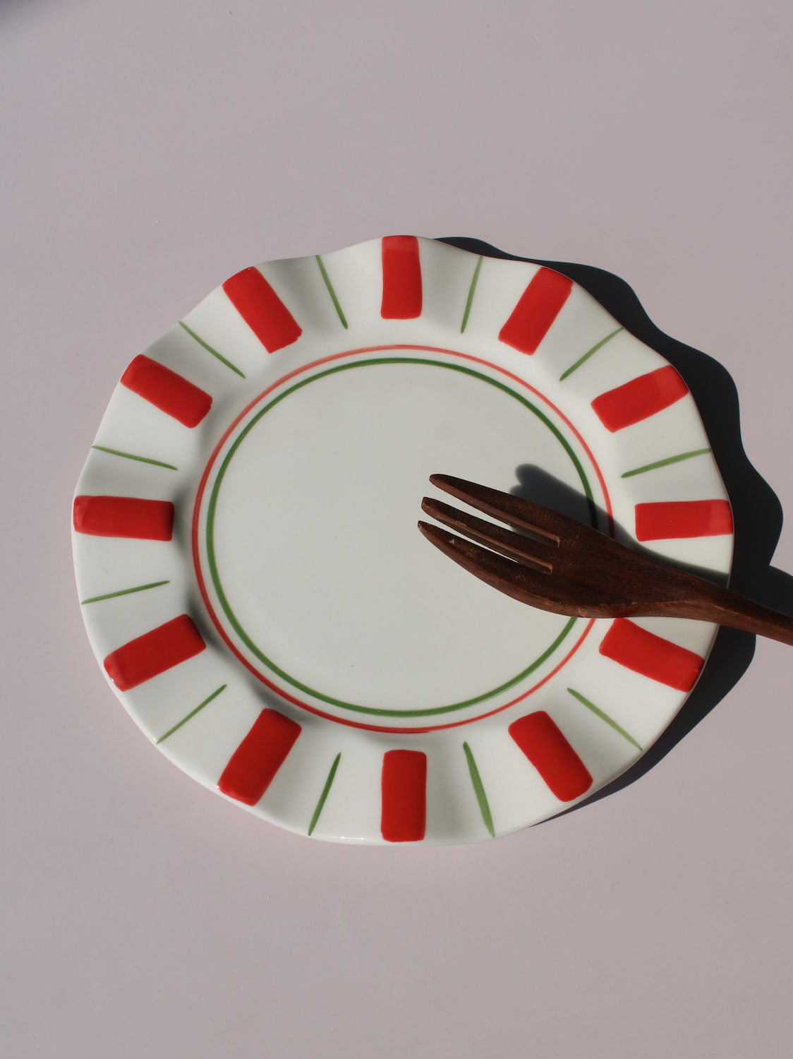 Riviera Ceramic Plate with red and green sunray pattern on scalloped rim, handmade ceramic dessert plate top view