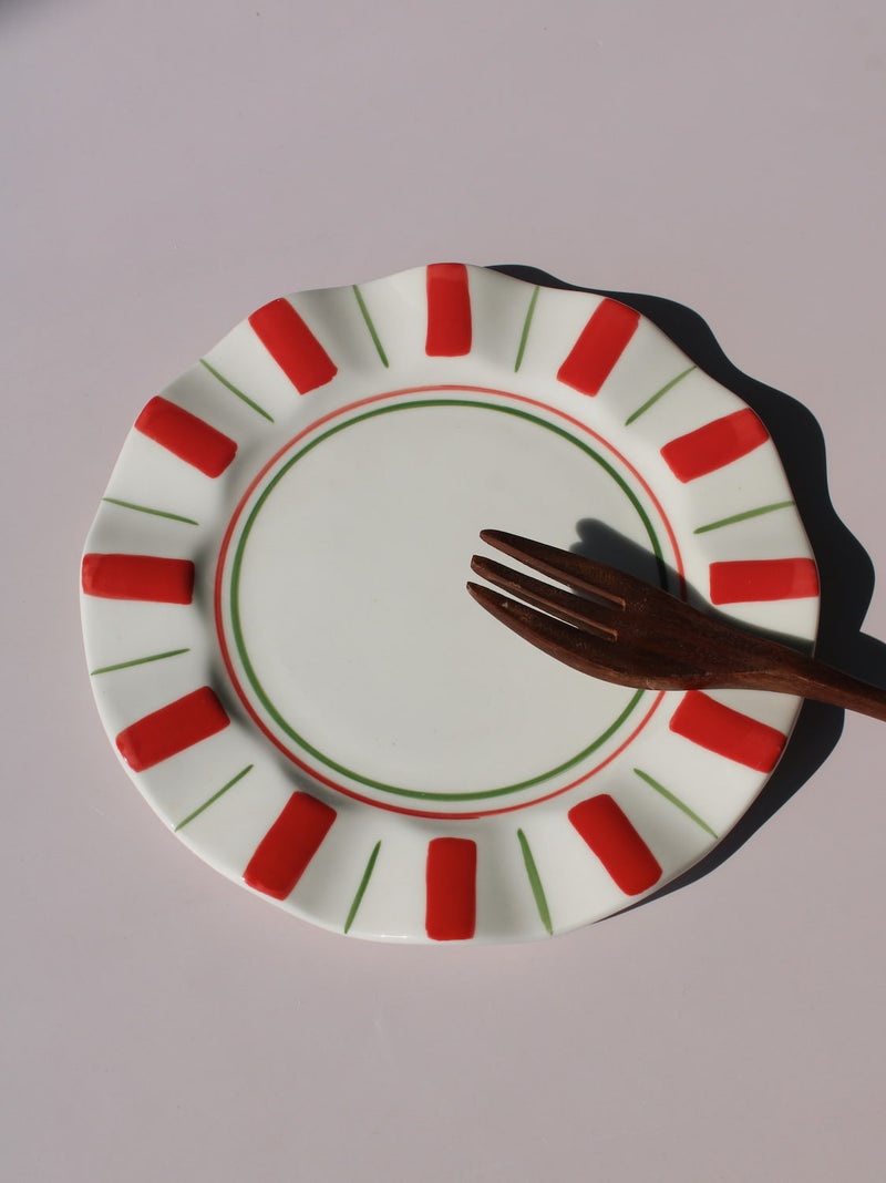 Riviera Ceramic Plate with red and green sunray pattern on scalloped rim, handmade ceramic dessert plate top view