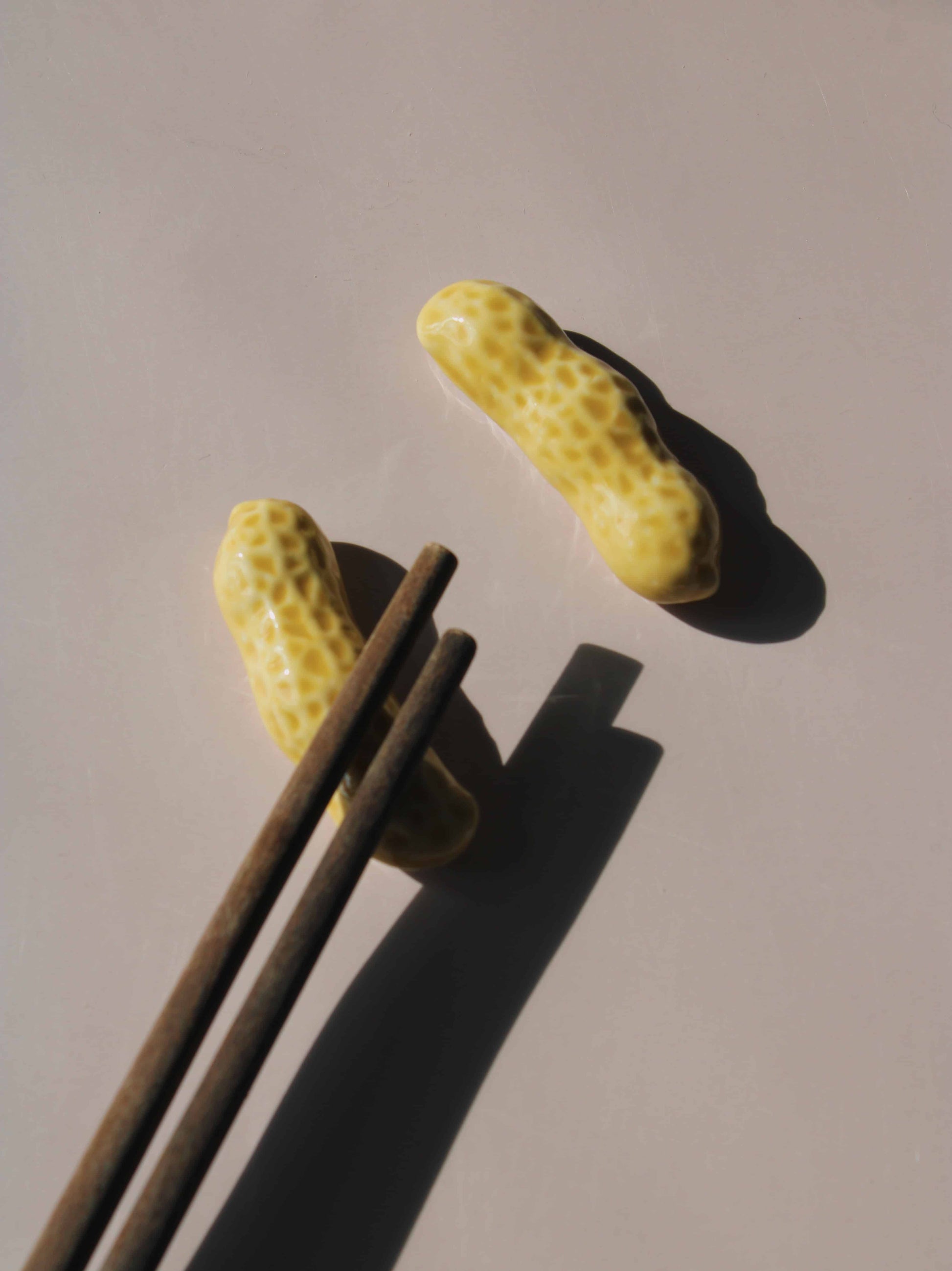 Peanut Ceramic Chopstick Rest Set shaped like peanut shells, styled with wooden chopsticks, handmade ceramic