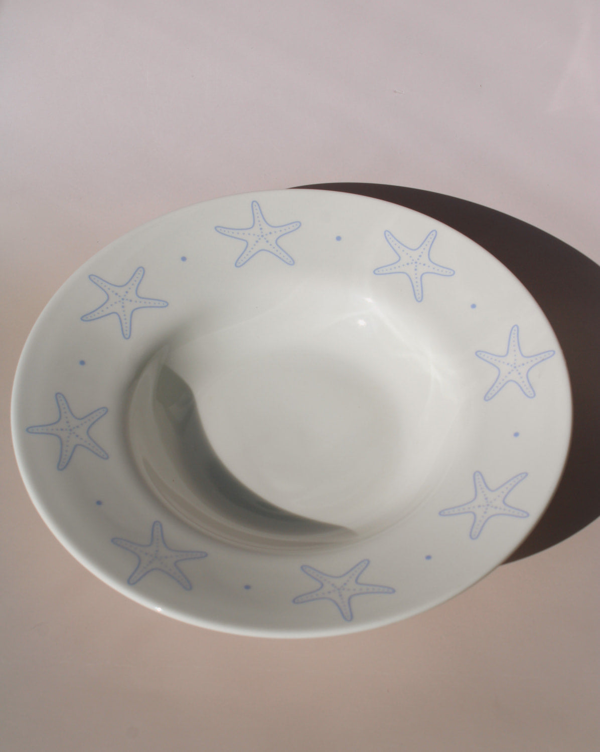 Astrella ceramic plate with blue starfish motif, coastal inspired tableware for seafood, pasta, or everyday dining.