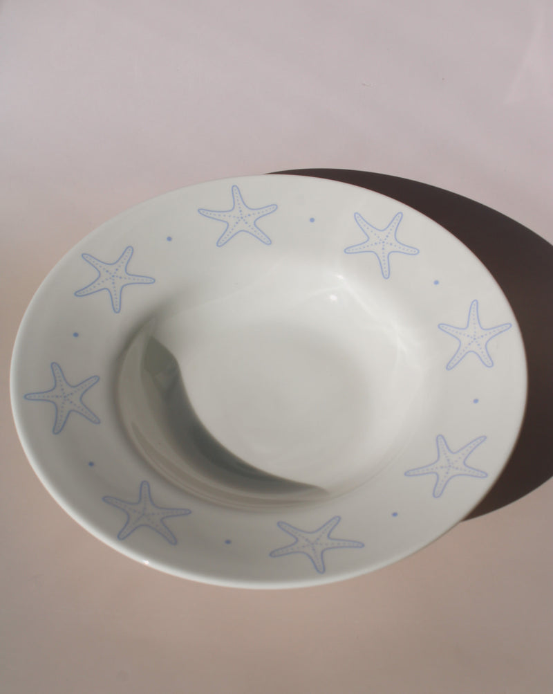 Astrella ceramic plate with blue starfish motif, coastal inspired tableware for seafood, pasta, or everyday dining.