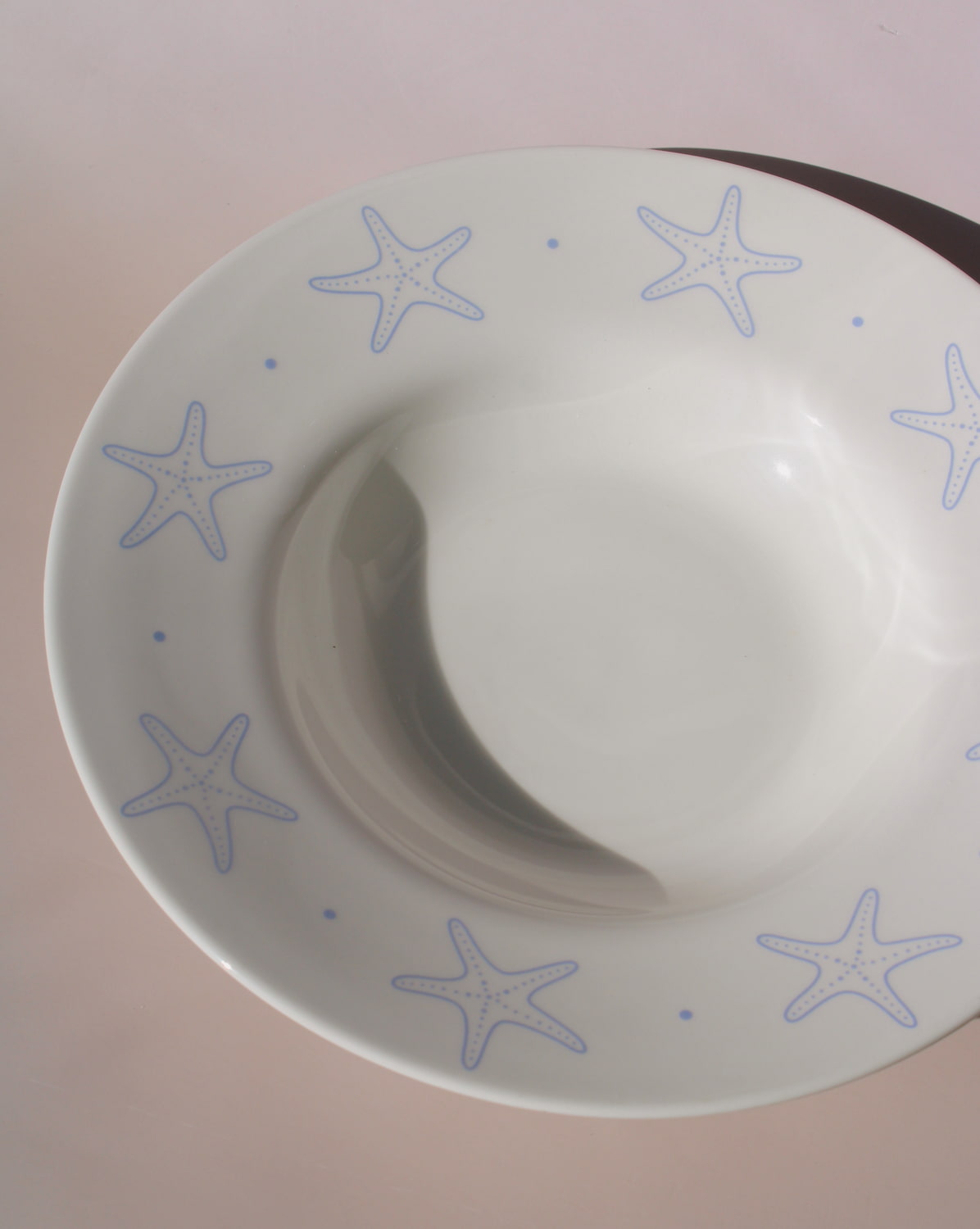Astrella ceramic plate with blue starfish motif, coastal inspired tableware for seafood, pasta, or everyday dining.