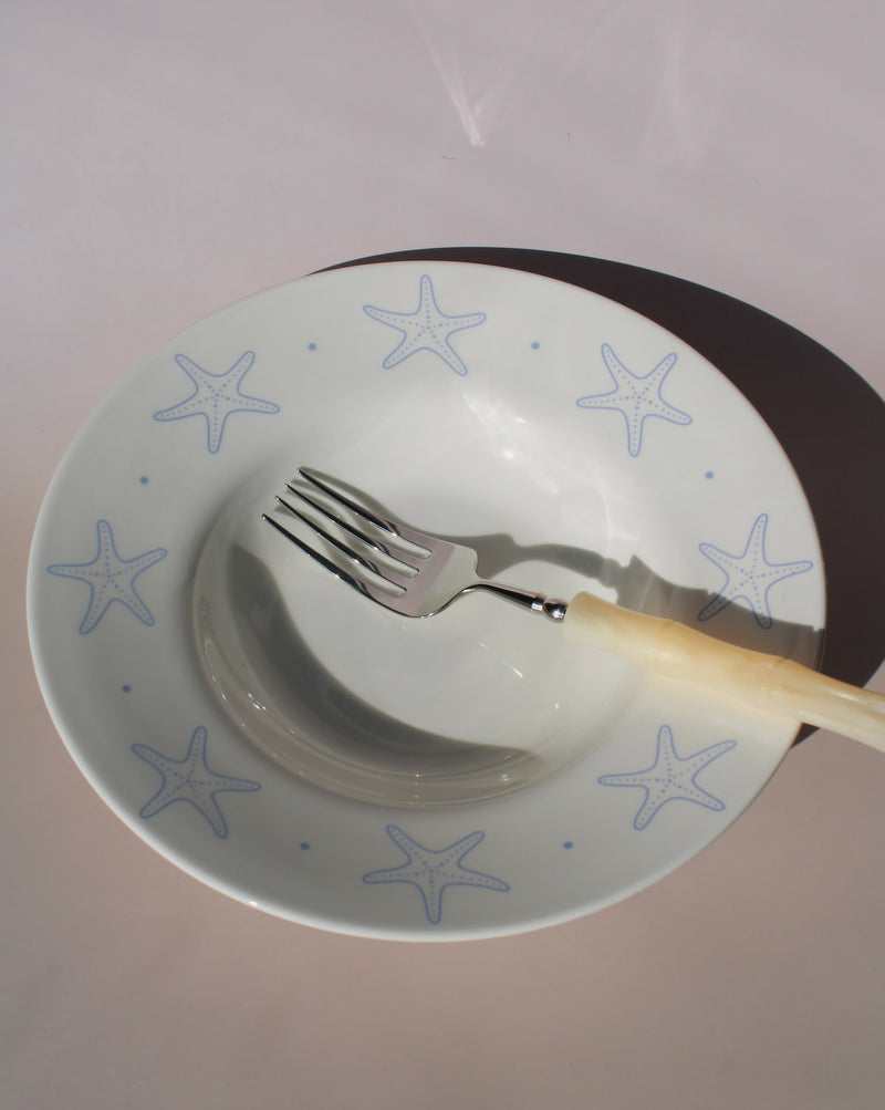Astrella ceramic plate with blue starfish motif, coastal inspired tableware for seafood, pasta, or everyday dining.