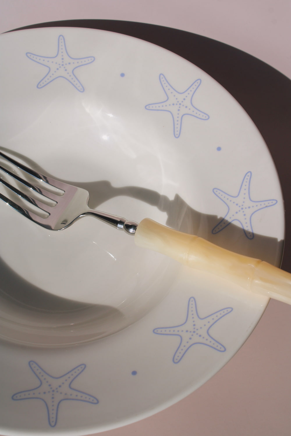 Astrella ceramic plate with blue starfish motif, coastal inspired tableware for seafood, pasta, or everyday dining.