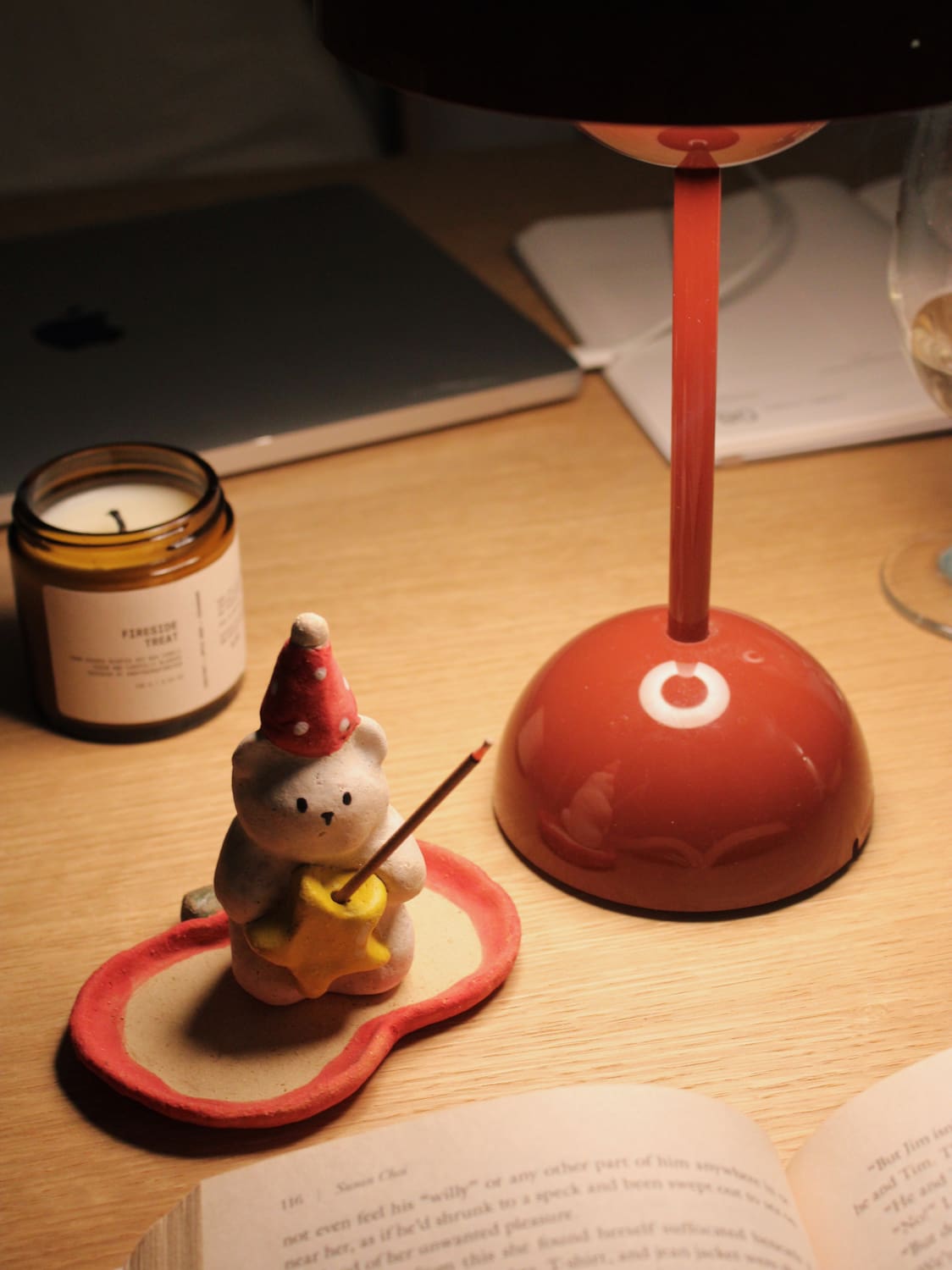 Teddy Ceramic Incense Holder with a lit incense stick, styled on a wooden surface with a candle and terracotta bowl in warm evening light.