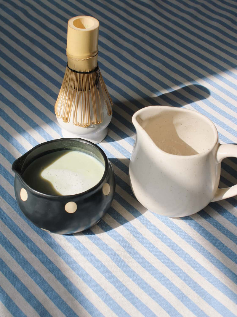 Mochi matcha bowl with deep glaze styled with bamboo whisk and ceramic pitcher