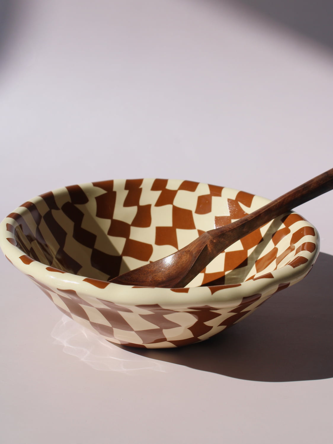 Nova Ceramic Bowl with brown and cream checkered pattern, styled with a green checkered spoon, handmade ceramic bowl top view