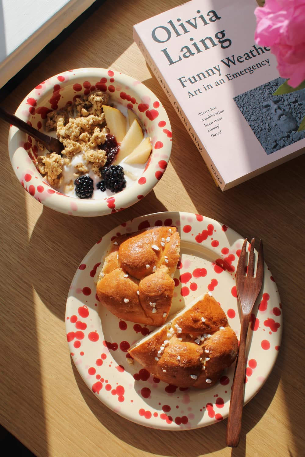 Dotty Ceramic Bowl and Dotty Ceramic Plate in matching cream with red speckled dot pattern, styled with a morning granola bowl and brioche.