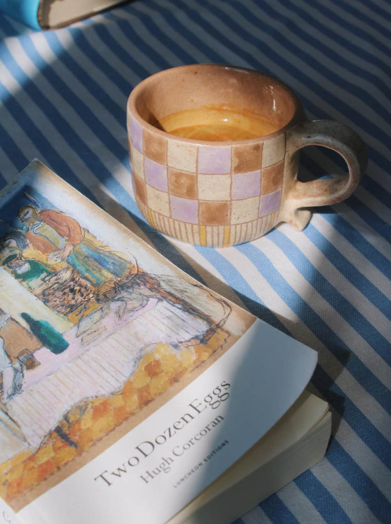 Calla handmade ceramic mug with soft checkered glaze, coffee cup styled with open book