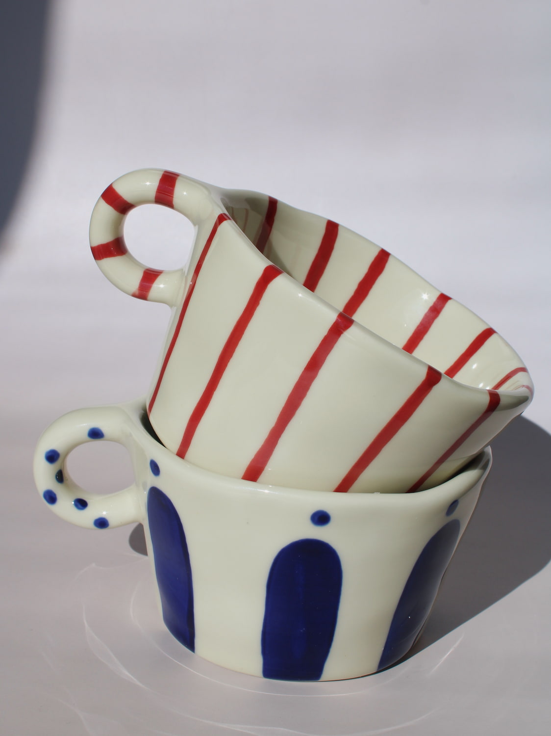 Enzo and Arlo Ceramic Mug with bold blue arch stripes and polka dot handle on cream base, handmade pottery coffee mug