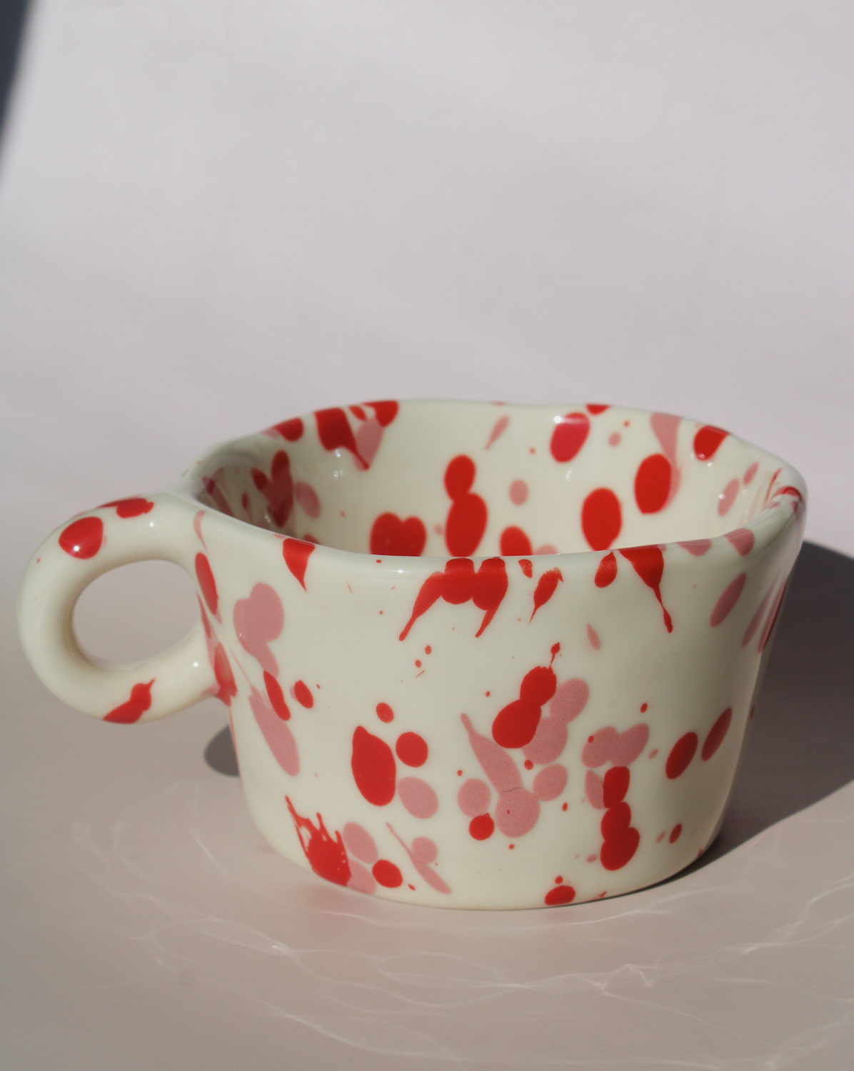 Red splatter ceramic espresso cup with rounded handle, handmade speckled coffee cup.