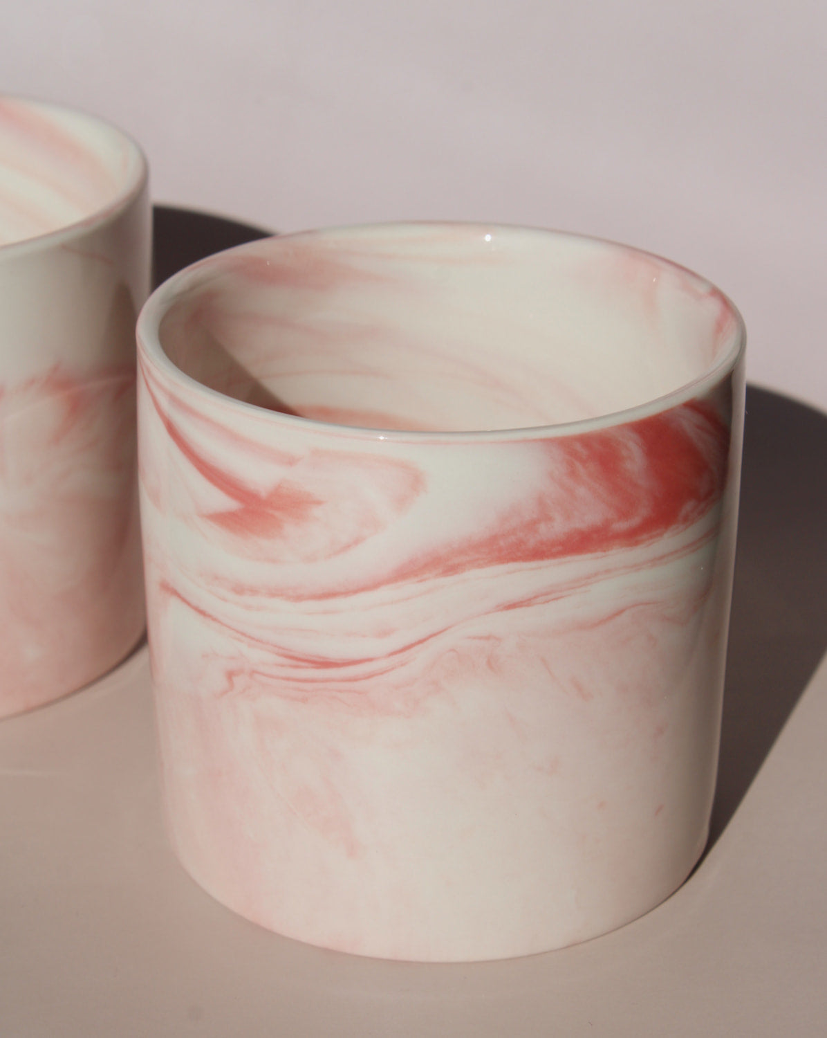Blush ceramic cup with soft pink marble swirl glaze, handmade stoneware cup for coffee, tea, or everyday drinks.