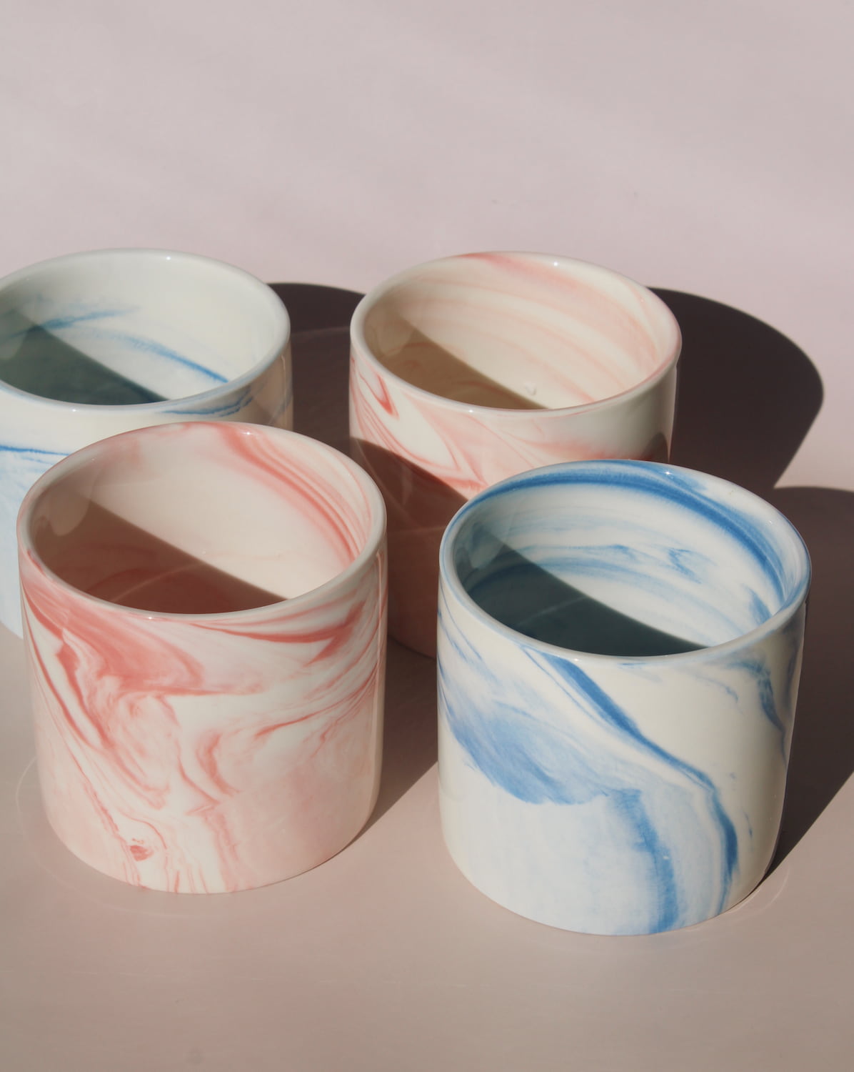 Blush and Sumi ceramic cups with pink and blue marble swirl glazes, handmade stoneware cups styled together.