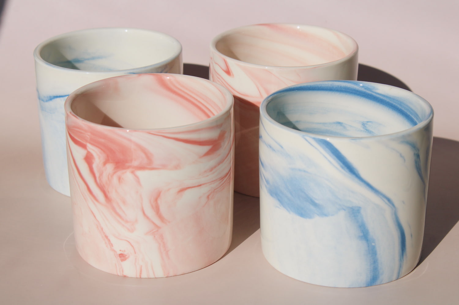 Blush and Sumi ceramic cups with pink and blue marble swirl glazes, handmade stoneware cups styled together.