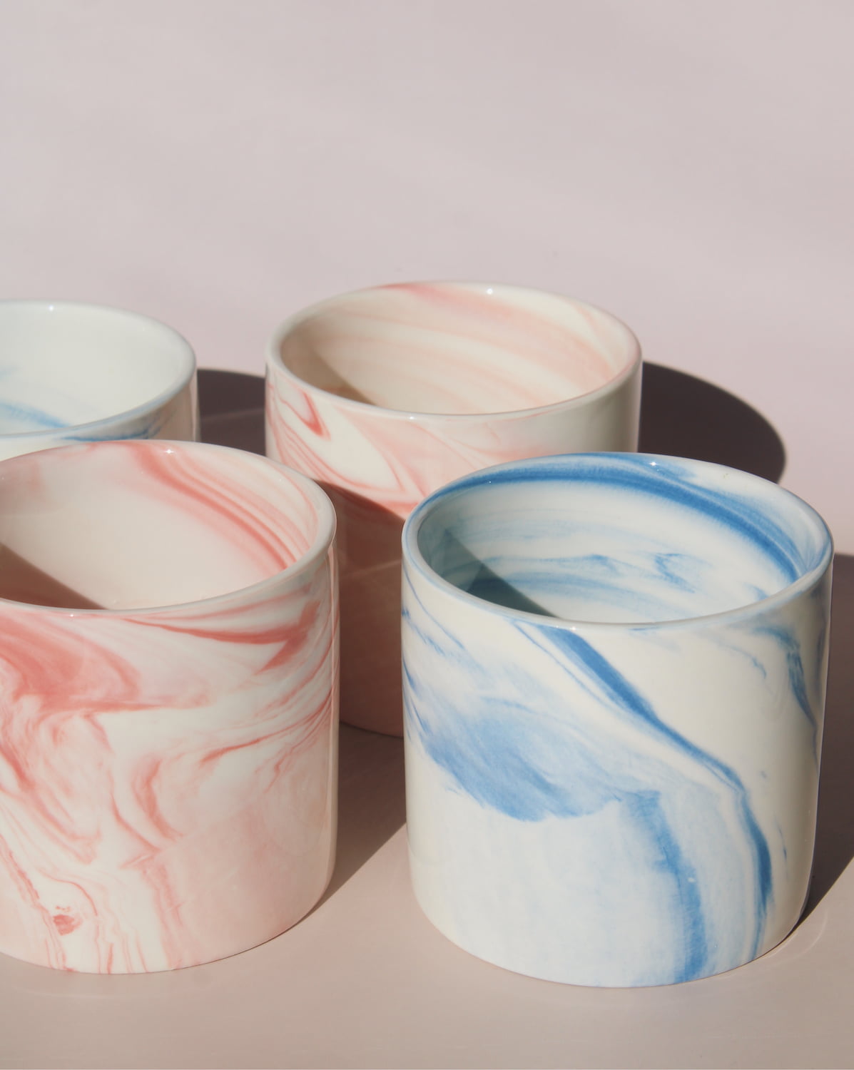 Blush and Sumi ceramic cups with pink and blue marble swirl glazes, handmade stoneware cups styled together.