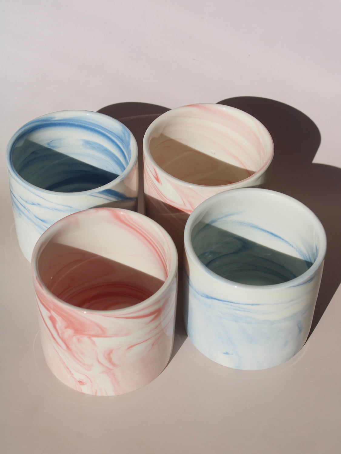 Blush and Sumi ceramic cups with pink and blue marble swirl glazes, handmade stoneware cups styled together.