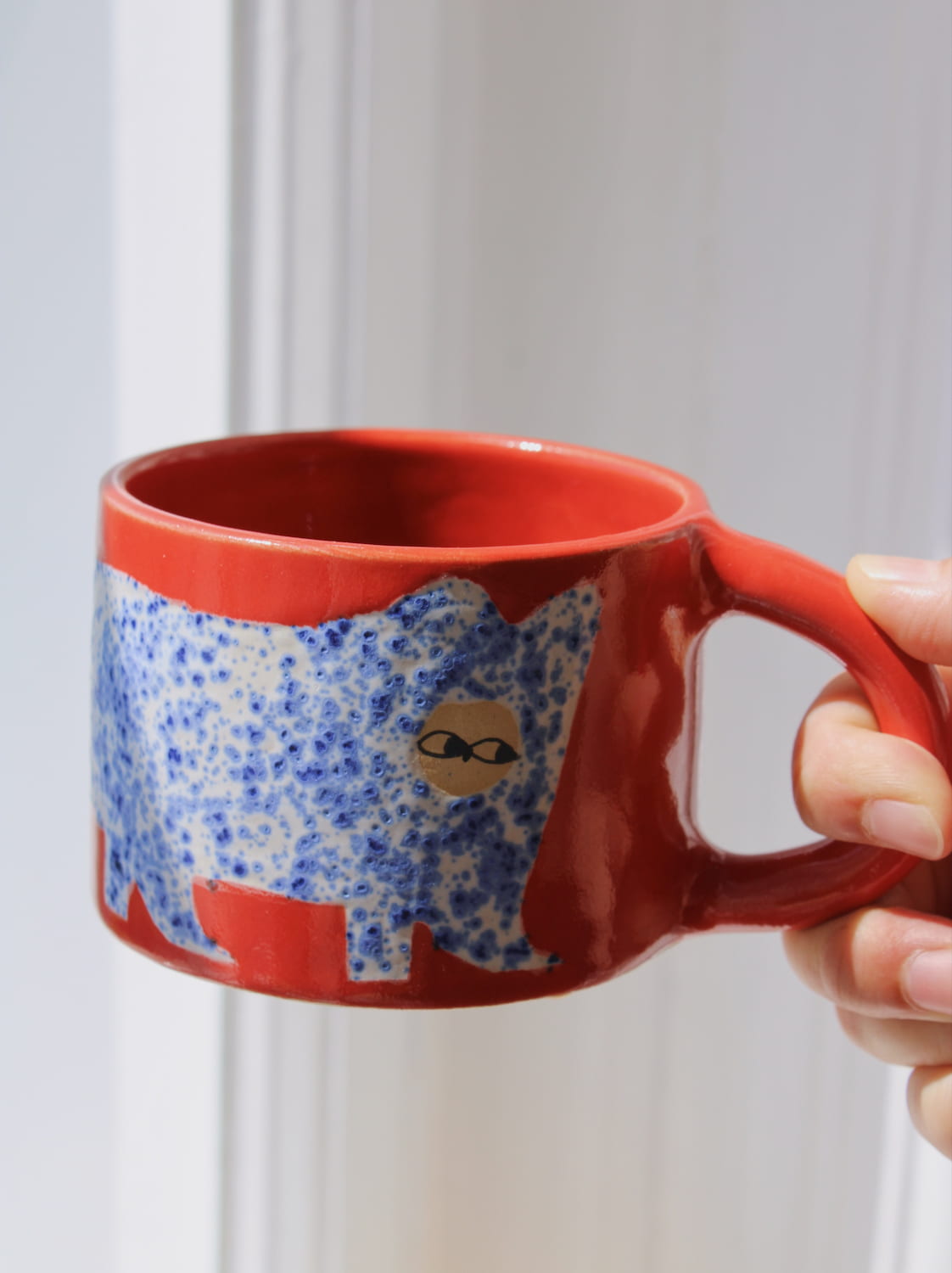 Scarlet Ceramic Cat Mug by Marta Shurpakova – handmade red ceramic mug with a playful cat design