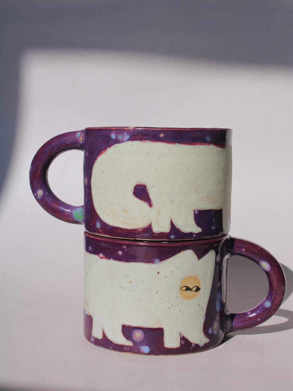 Mulberry Ceramic Cat Mug by Marta Shurpakova – handmade purple and cream ceramic mug with a playful cat design