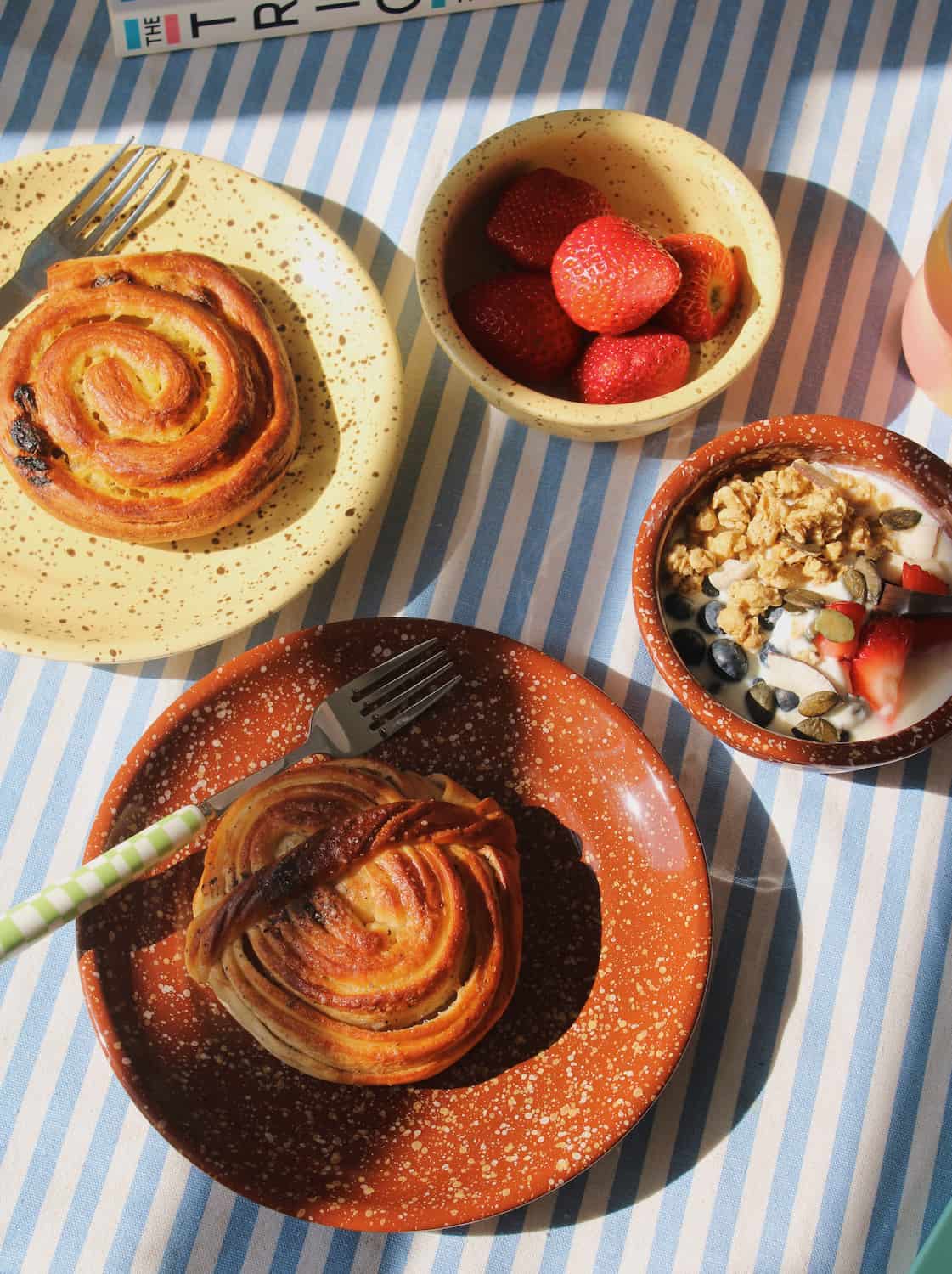 Ocre ceramic bowl and plate with speckled glaze styled with pastry, paired with Roca ceramic bowl and plate, handmade tableware set.