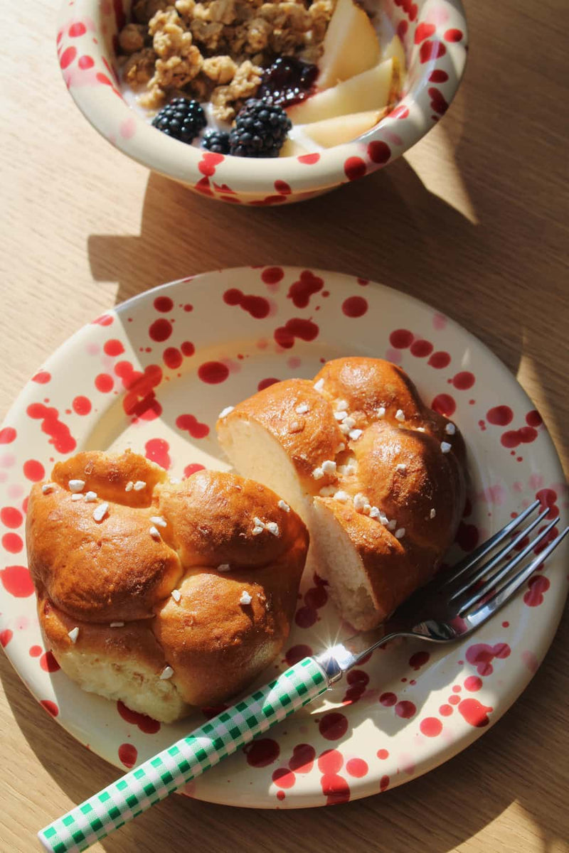 Dotty Ceramic Plate in cream with red speckled dot pattern, styled with a brioche 