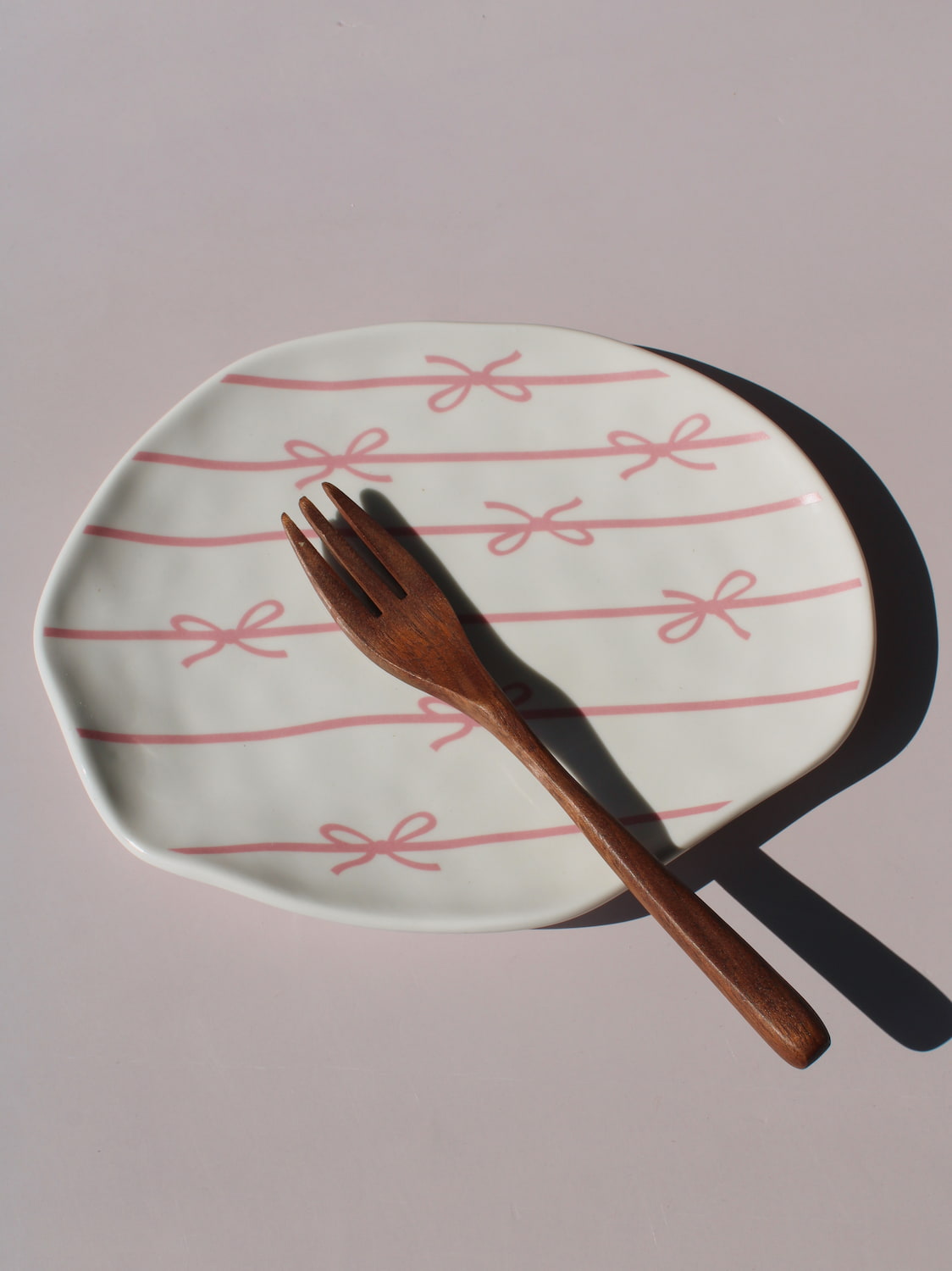 Lina Ceramic Plate with pink bow and ribbon line pattern, organic-shaped handmade ceramic plate top view