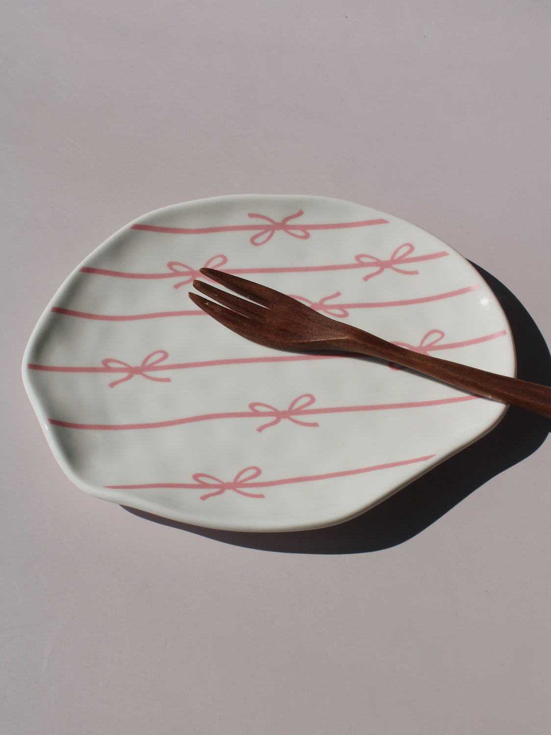 Lina Ceramic Plate with pink bow and ribbon line pattern, organic-shaped handmade ceramic plate top view